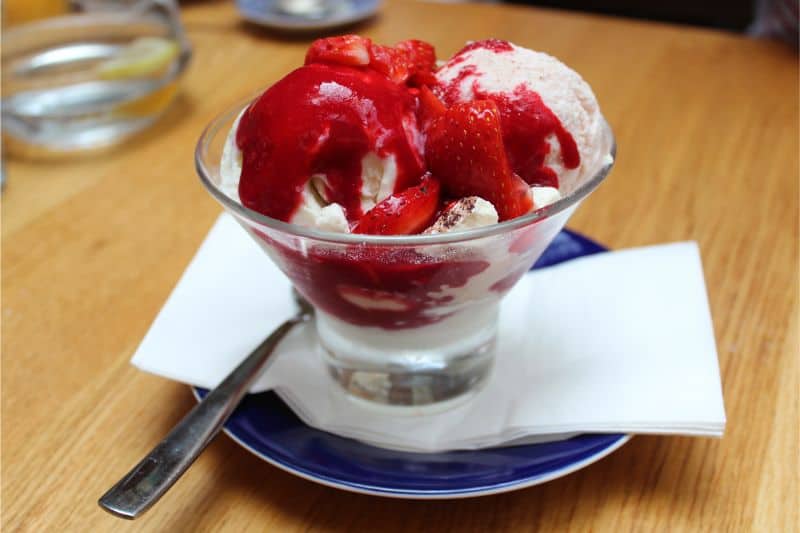 草莓芝士蛋糕香草杯和草莓冰淇淋，新鲜草莓，草莓酱，蛋白霜，乳清干酪酸奶和杏仁片